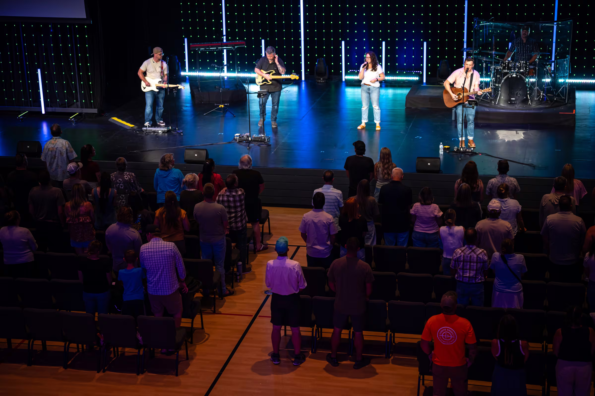 The Greenhouse Church worship band leading a gathering as the congregation stands