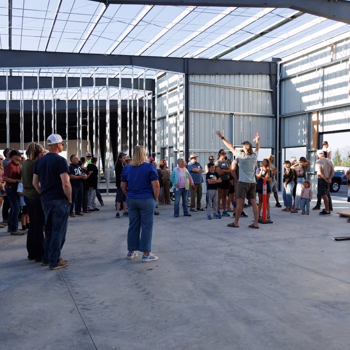 Congregation gathered inside the open steel frame for a time of worship